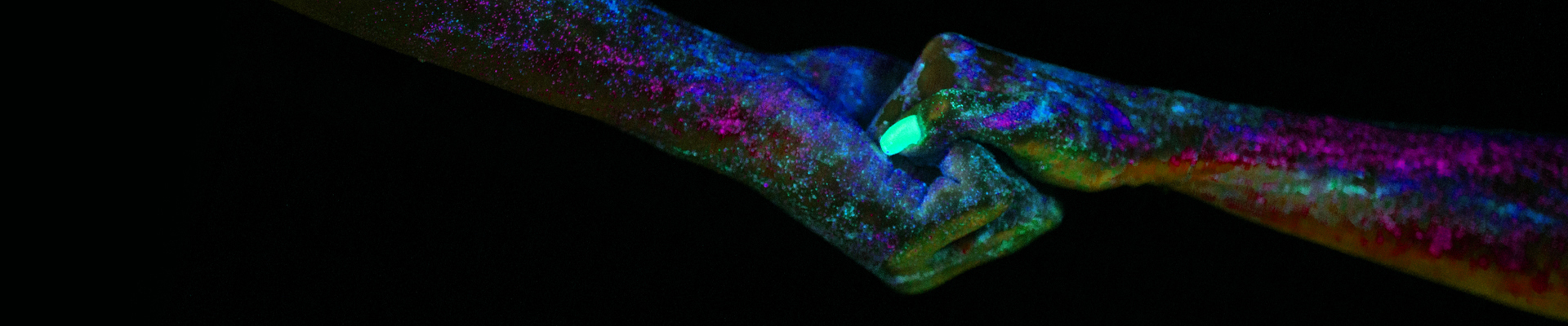 Two persons holding hands. Nails in neongreen with dark background.