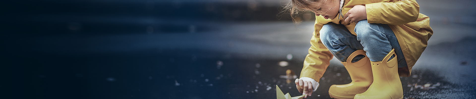 Little child playing in the rain 