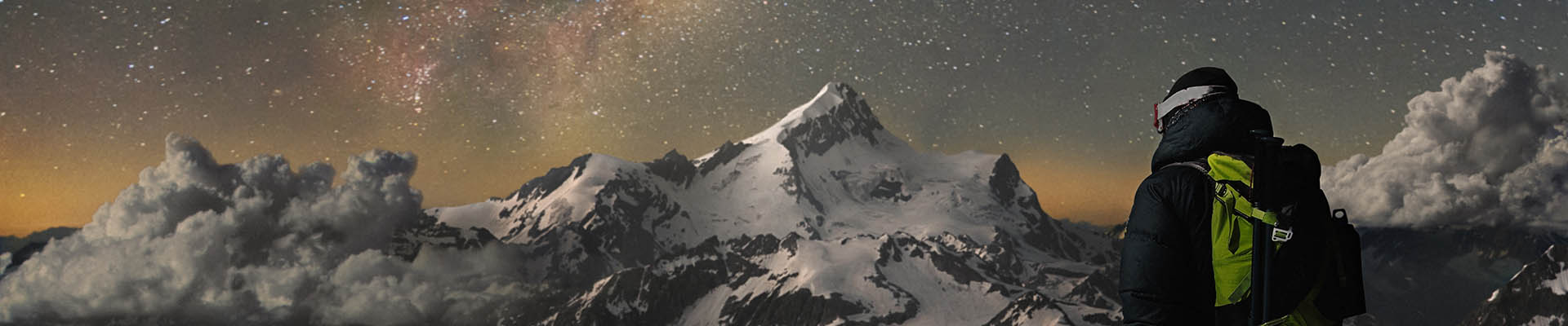 A person in ski clothes looking at a snow covered mountain