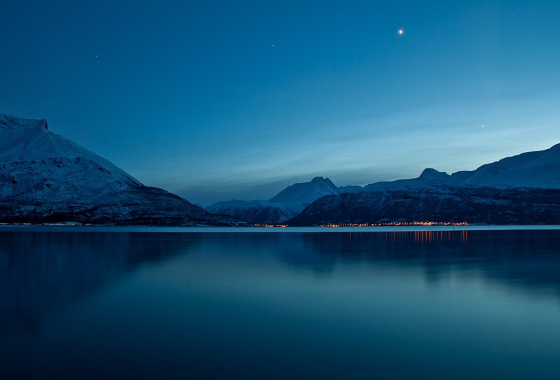 Still lake with mountains in the background
