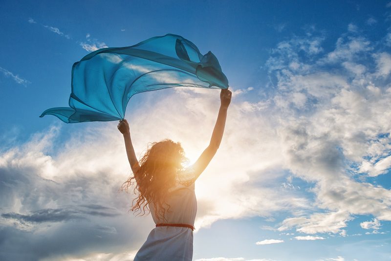 blue sky girl holding cloth high