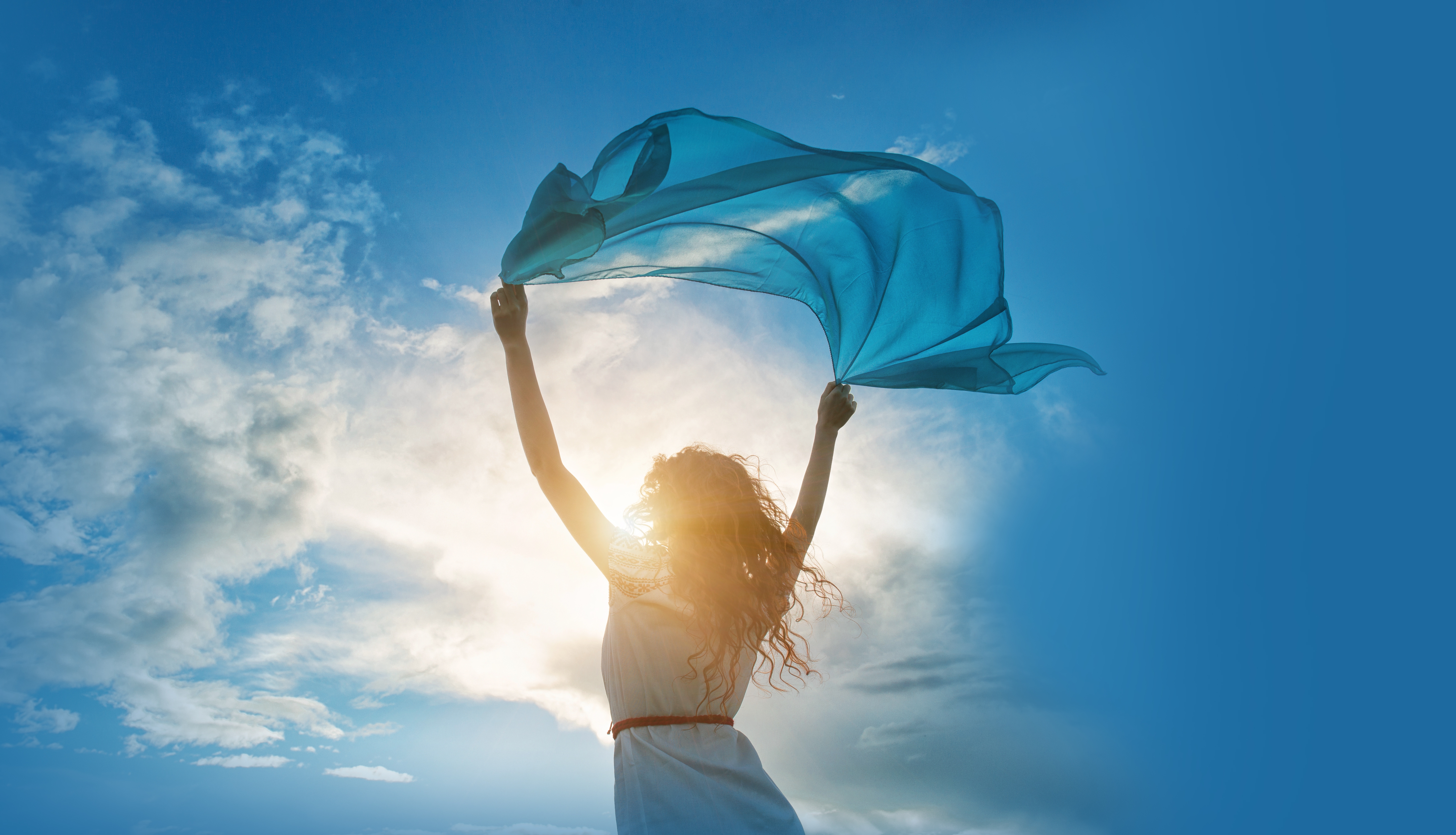 A girl holding a scarf towards the sky